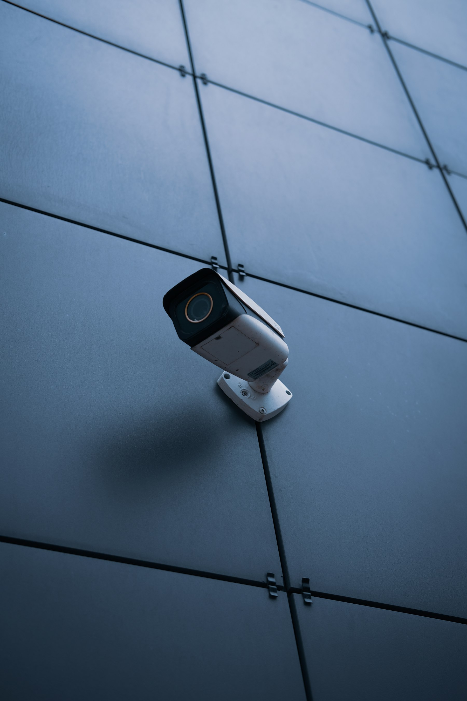 Professional security camera mounted on a dark modern facade
