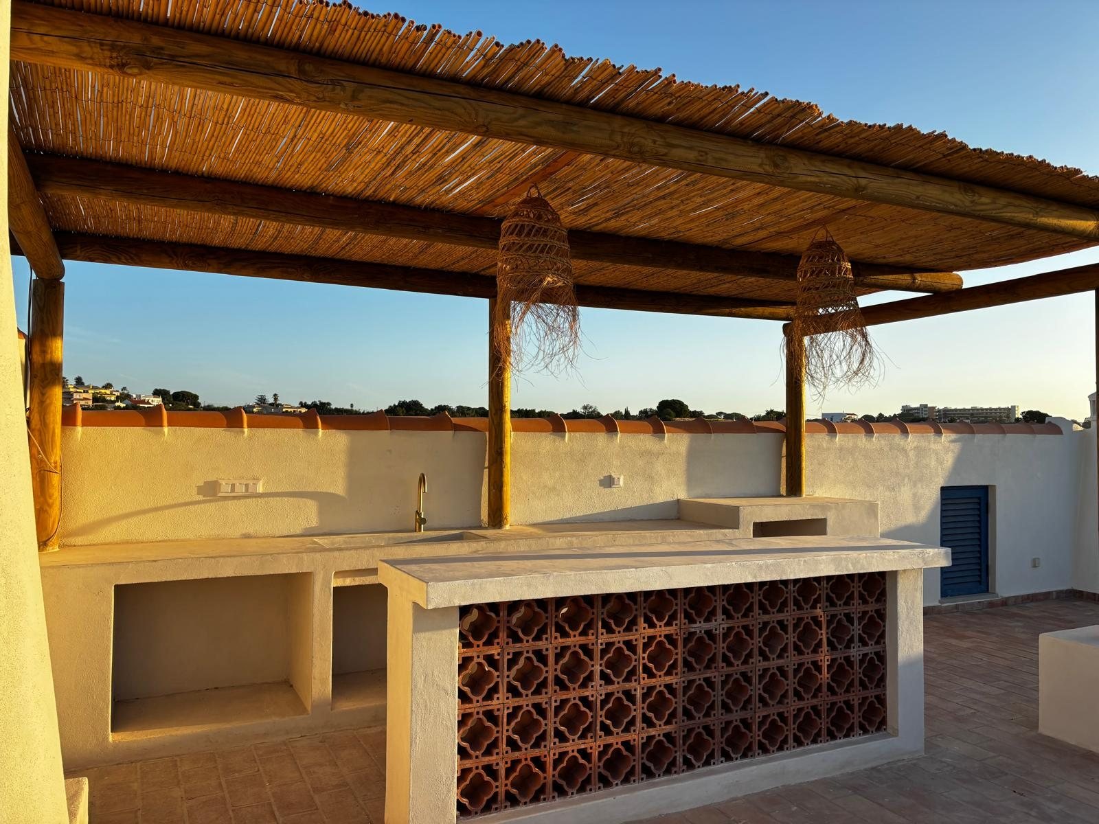Quinta Girassol rooftop bar at sunset with cobogo terracotta kitchen