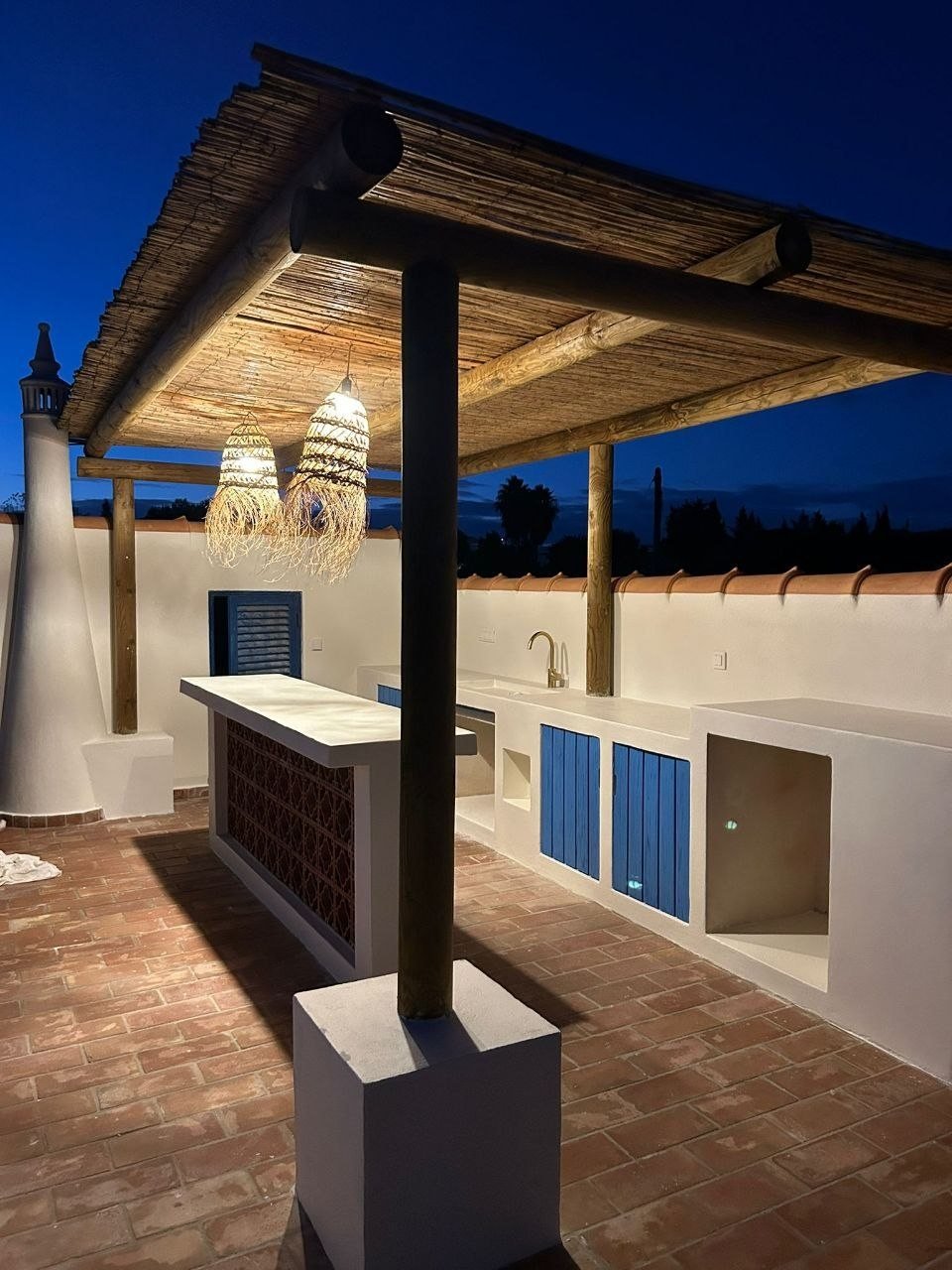 Quinta Girassol rooftop bar at night with rattan pendant lights